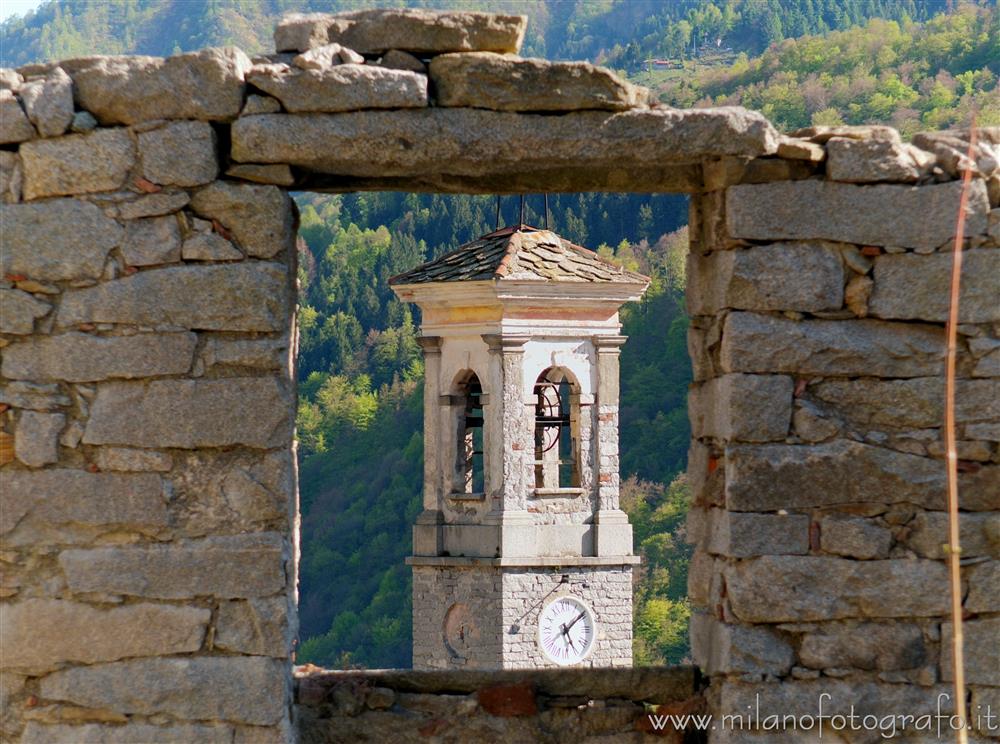 Campiglia Cervo (Biella, Italy) - Bell tower of the Oratory of the Saints Sebastian and Fabian from behind a stone wall